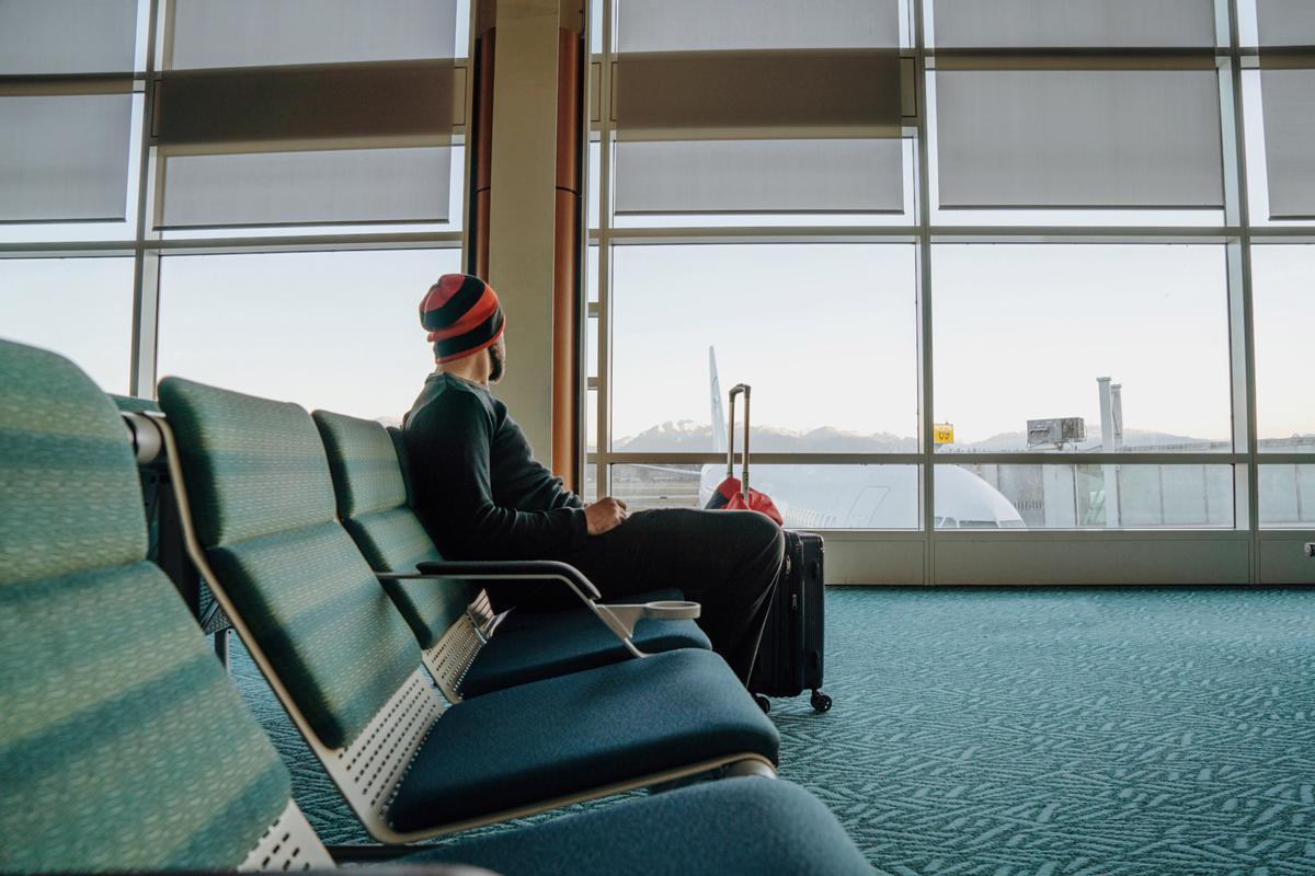 Un viajero esperando en la terminal de un aeropuerto.