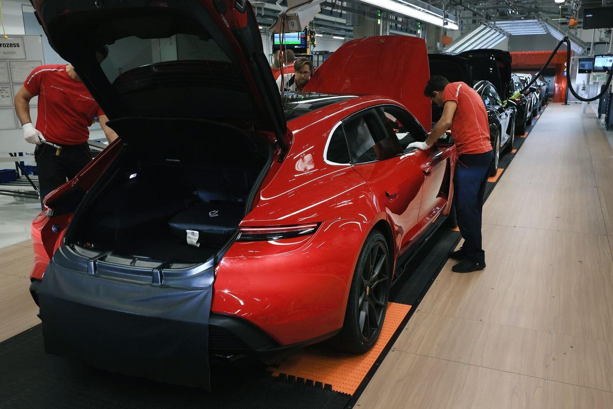 Los empleados trabajan en las carrocerías de los automóviles de lujo Porsche Taycan totalmente eléctricos en la línea de producción de la fábrica de Porsche AG en Stuttgart, Alemania.