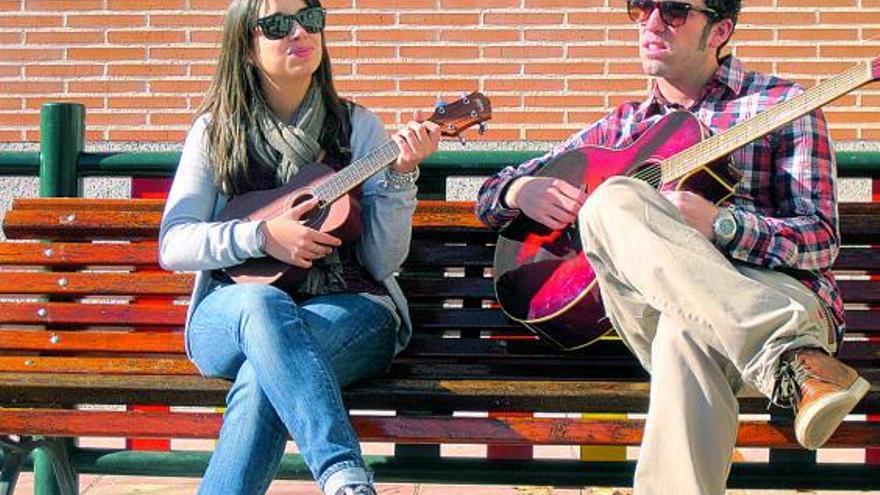 Paula Rojo y Tristán Armas, sentados al sol en una calle de Madrid.