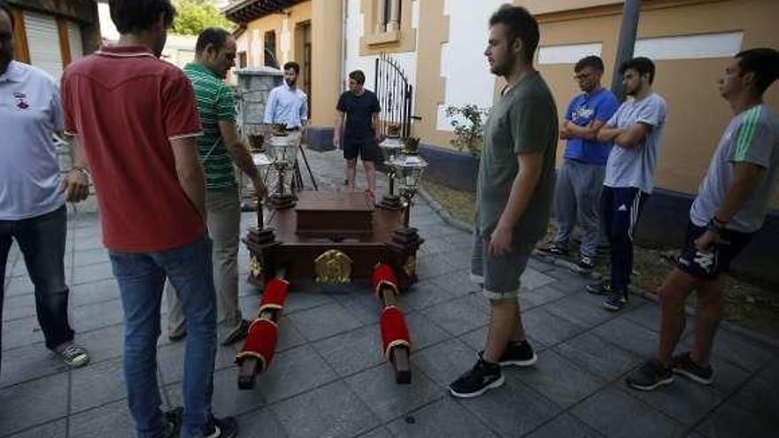 Miembros de la cofradía, ayer, preparando las andas para la procesión del lunes.