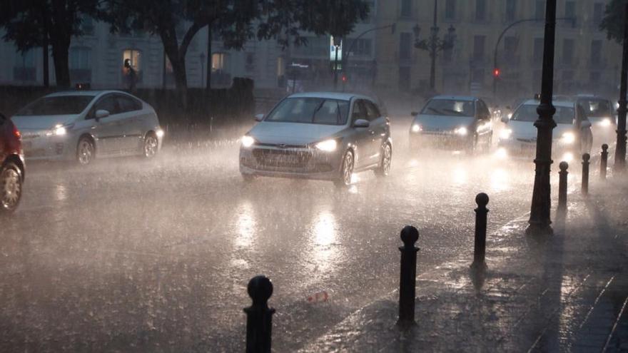 Varios coches circulan bajo la lluvia en Valencia.