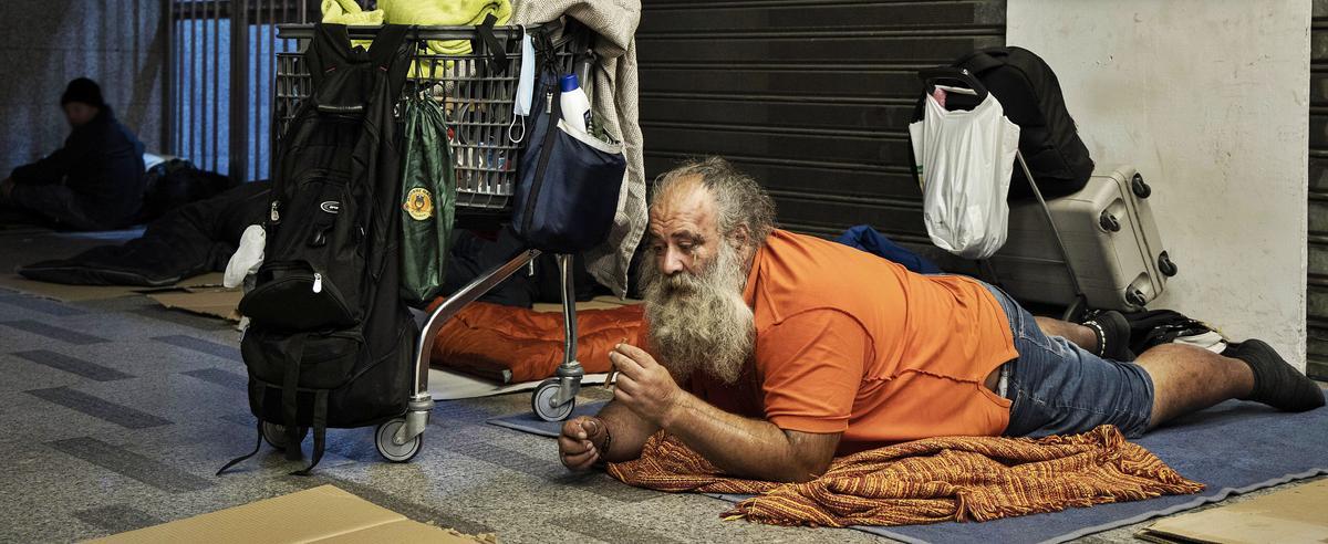 Simón se enciende un puro sobre una manta en el vestíbulo donde duerme. germán caballero