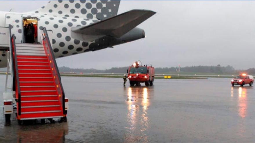 La escalerilla del avión, tras el desalojo, con los bomberos al fondo.