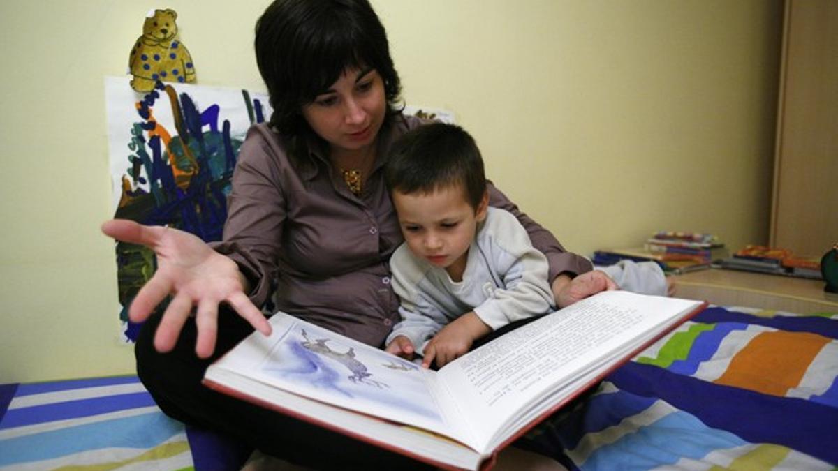 Una madre le lee un cuento a su hijo.