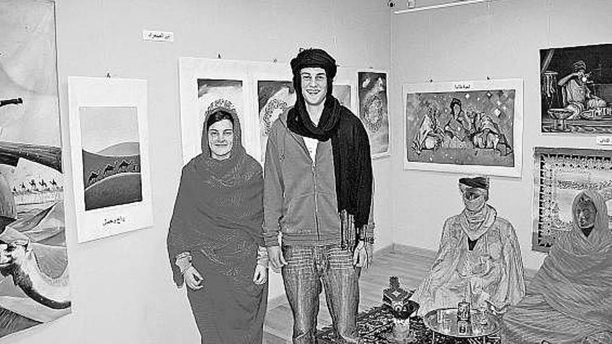 Los alumnos Daniel González y Lucía Martínez, junto a las pinturas de la exposición.