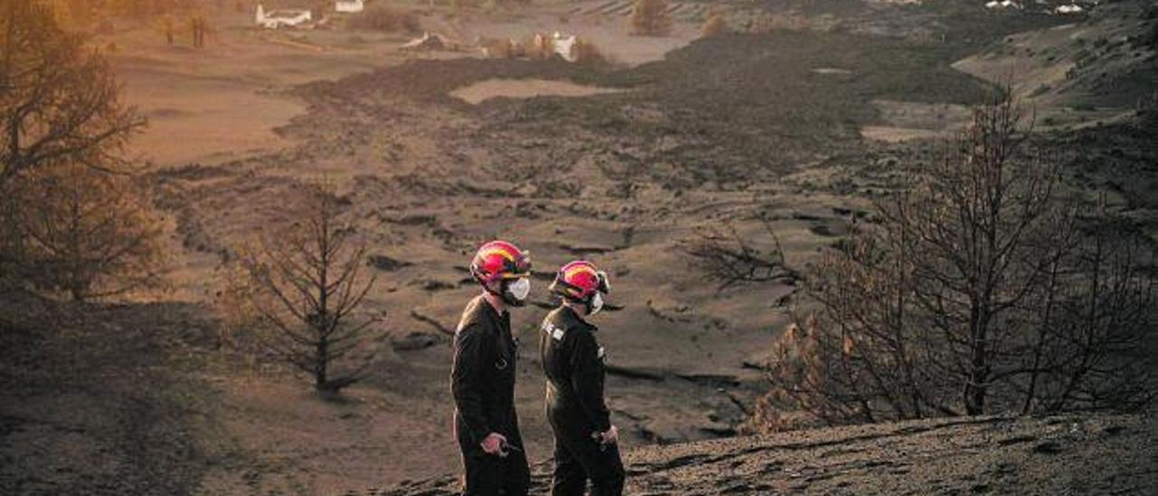 Dos profesionales de la UME inspeccionan la zona próxima al volcán.