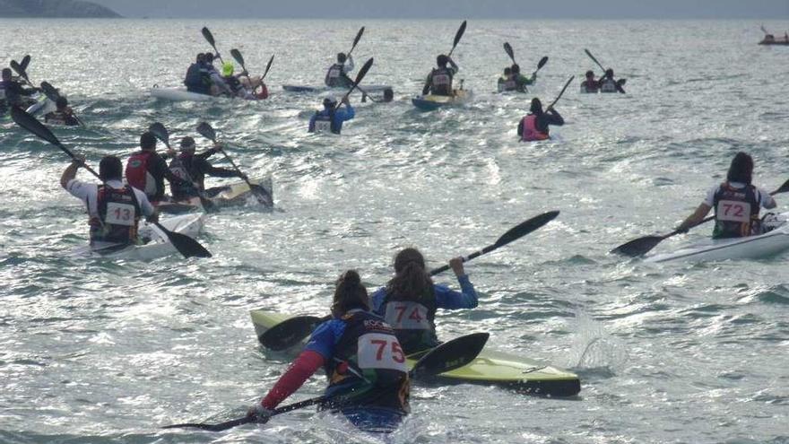 Los piragüistas corren hacia sus embarcaciones para iniciar la regata que los llevaría desde A Lanzada hasta Portonovo. // Muñiz