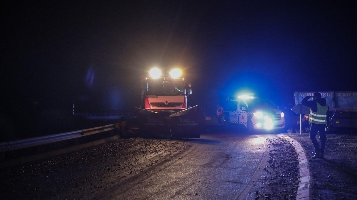 Limpieza de la calzada tras la caída de la carga de un camión de grava