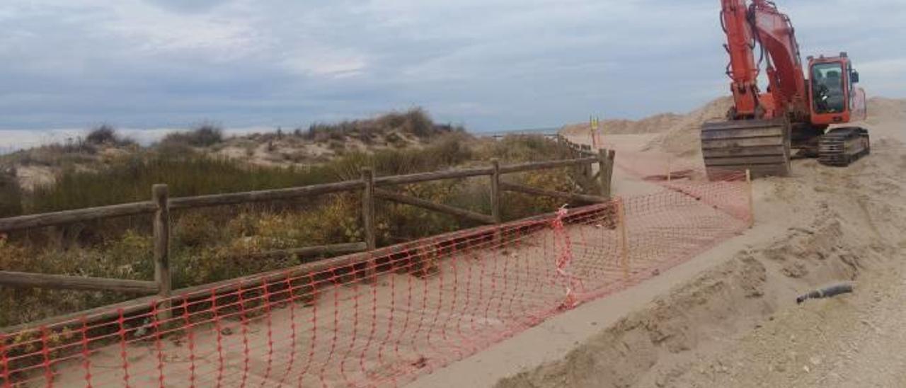 Arriba, una excavadora saca arena junto a una de las dunas protegidas de l&#039;Auir. Debajo, montones para ser cargados y transportados.