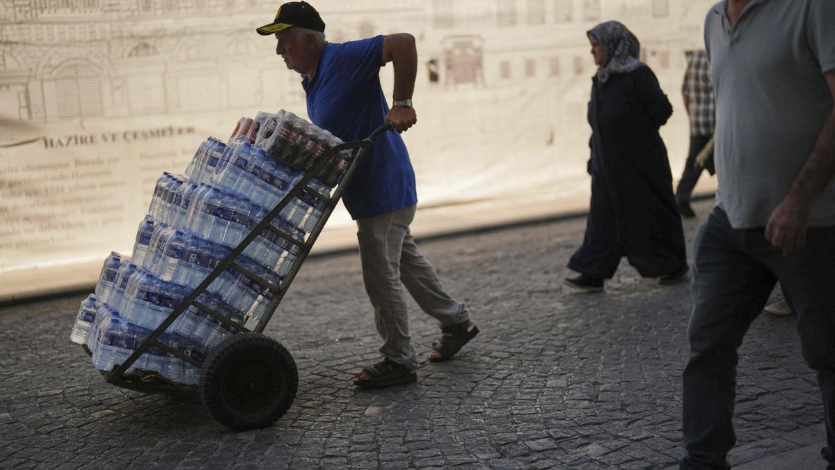 Un repartidor con una carretilla cargada con botellas de agua, este viernes en Estambul.