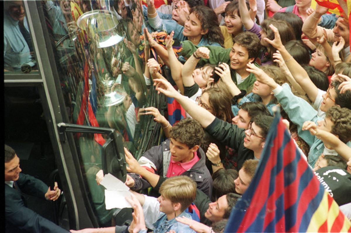 Joves seguidors bloquegen l’autocar que porta els campions cap a la plaça de Sant Jaume per poder veure de prop la Copa d’Europa i felicitar els jugadors.