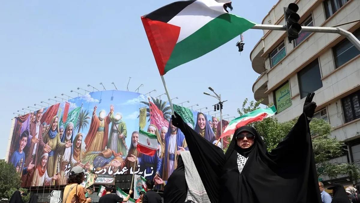 Un mujer ondea una bandera palestina en una protesta contra los ataques de Israel.