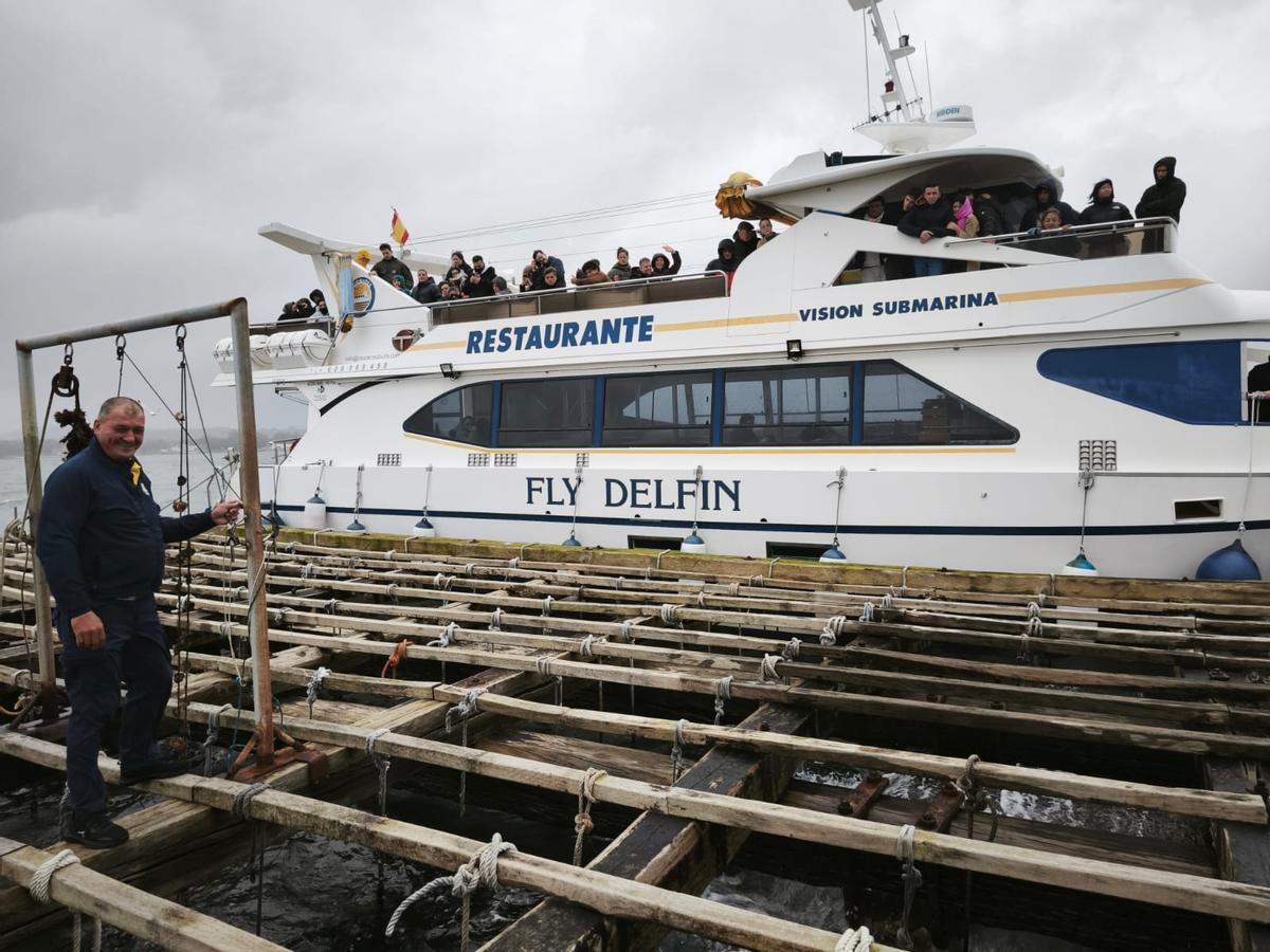 Los alumnos, subidos al catamarán «Fly Delfín», reciben explicaciones sobre las bateas.