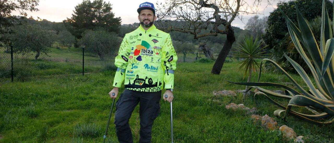 El piloto ibicenco Toni Vingut, apoyado en sus muletas, posa en el terreno de su casa en Sant Antoni, donde reposa tras su experiencia en el Rally Dakar. | JUAN A. RIERA