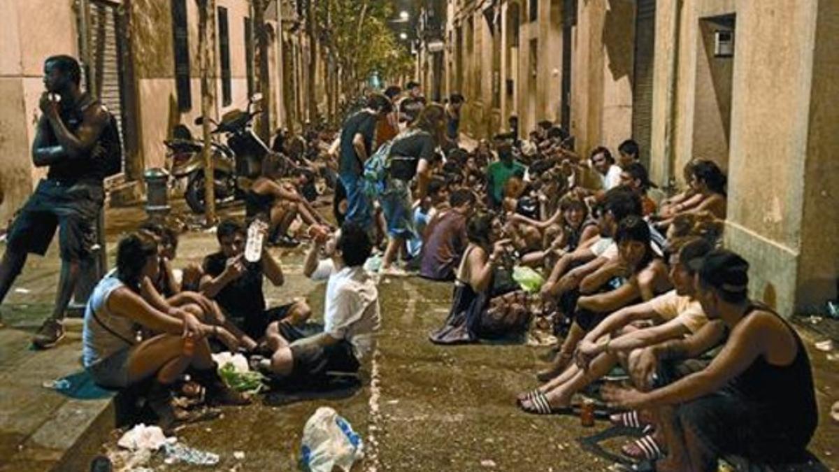 Un grupo de jóvenes hacen botellón cerca de la plaza del Raspall, la madrugada de ayer.