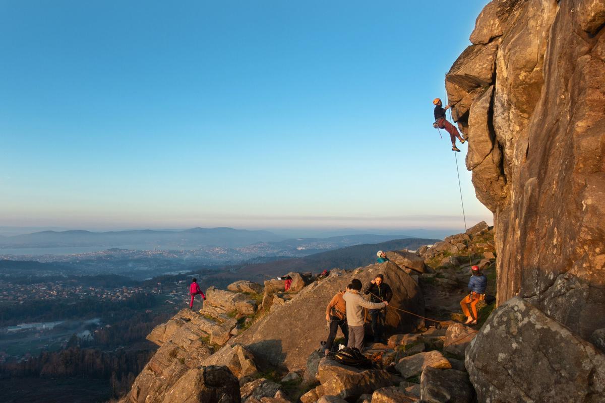 ESCALADORES DEL CLUB MONTAÑEROS CELTAS DURANTE UN ENTRENAMIENTO DE ESCALADA EN EL MONTE DE O GALIÑEIRO. Un grupo de montañeros escala una roca del Galiñeiro con la impresionante panorámica de Vigo al fondo. BISMARK