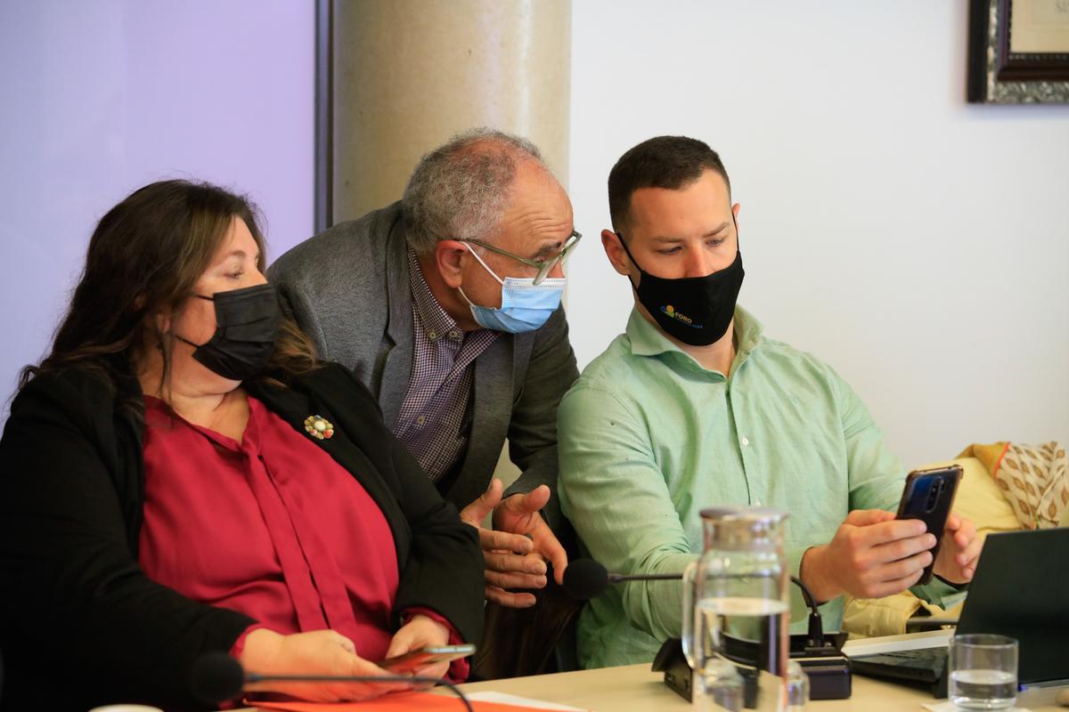 Joan Torres conversa con el portavoz de PSOE-Reinicia, Simón Planells, ante la atenta mirada de Cristina Ribas.