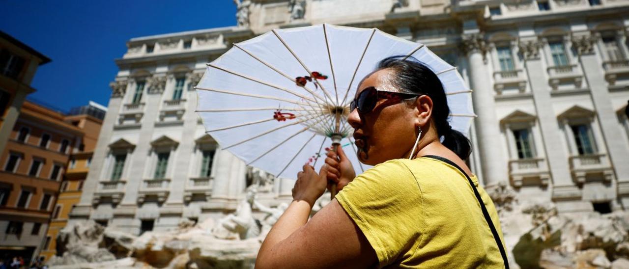 Una turista se refugia del calor en la Fontana di Trevi.