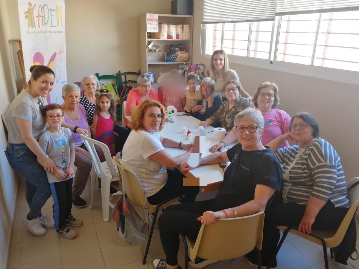 Taller de flores de papel para montar la cruz de mayo. La falta de espacio obligó a salir al pasillo.