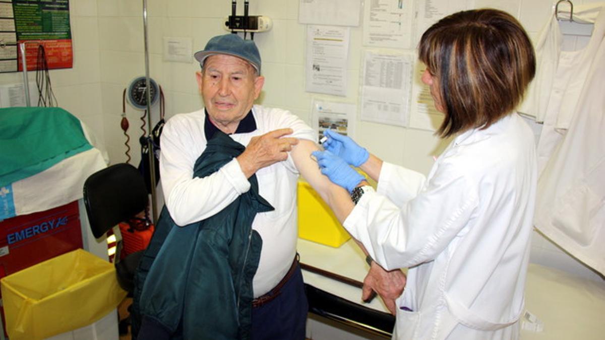 Una enfermera inyecta la vacuna antigripal a un paciente en el CAP Santa Maria de Lleida.