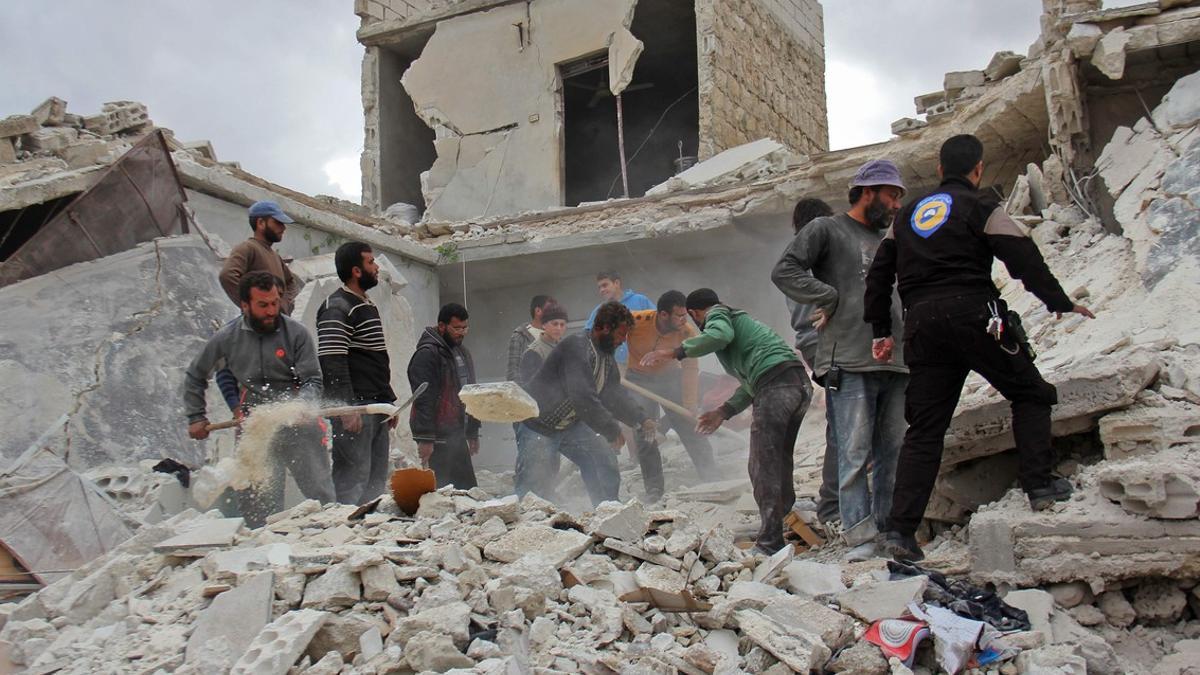 Civiles y miembros de equipos de rescate inspeccionan un edificio destruido en Kafar Jales, en las afueras de Idleb, tras ataque aéreos de aviones sirios y rusos, el 16 de noviembre.