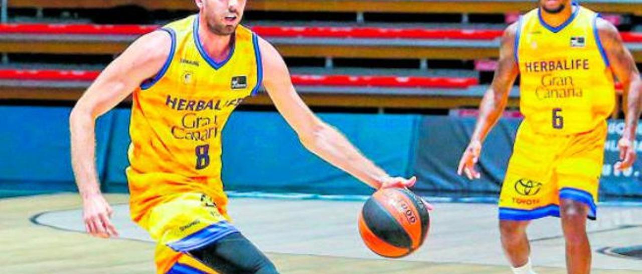 Amadeo Della Valle, escolta del Herbalife Gran Canaria, bota el balón, con Andrew Albicy, justo detrás.