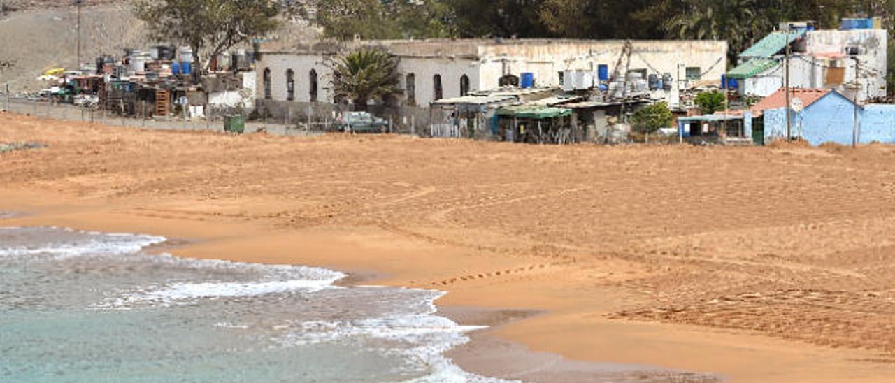 El mar baña la arena colocada en la playa de Tauro, con el grupo de casas afectadas por el nuevo paseo.