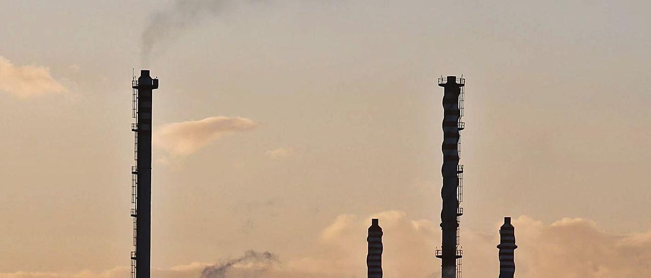 Las chimeneas de la fábrica de Azsa, recortadas contra el cielo del anochecer.