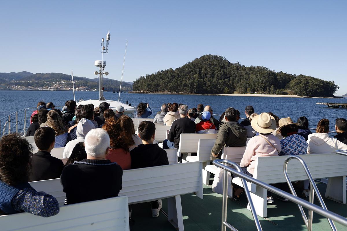 Viajeros a bordo del barco que une Combarro y Tambo toman imágenes de esta isla.