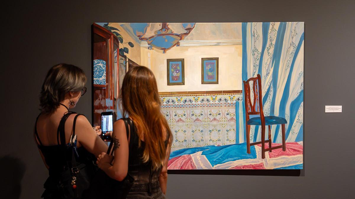 Dos personas observan una de las obras de la exposición.