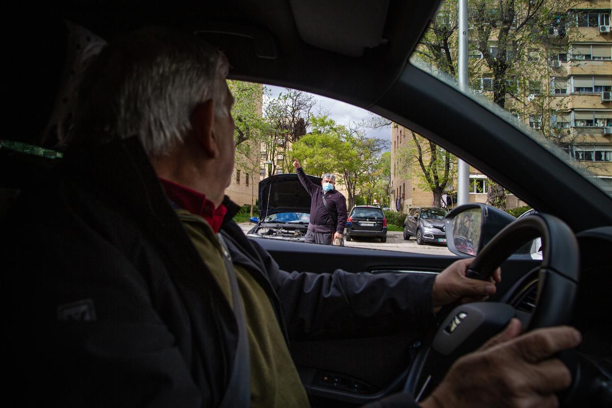 Félix López-Rey saluda desde su coche a un vecino de Orcasitas que se dirige al campo de fútbol.