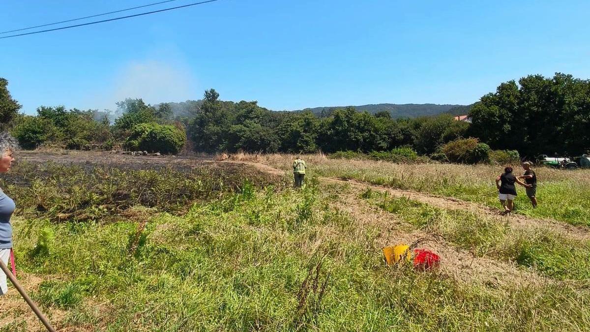 Vecinos y un efectivo después de la extinción del incendio.