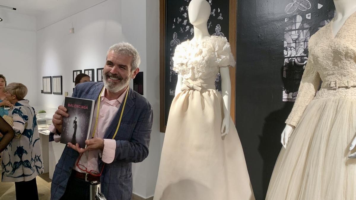 El diseñador Lorenzo Caprile junto a dos vestidos de novia de Cristóbal Balenciaga