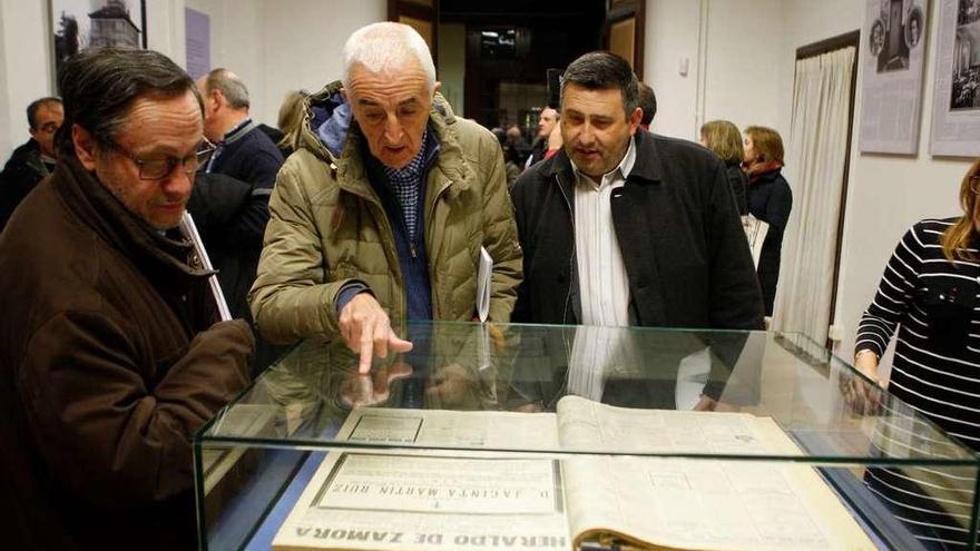 Varios hombres observan la información sobre una pionera publicada en &quot;El Heraldo de Zamora&quot;.