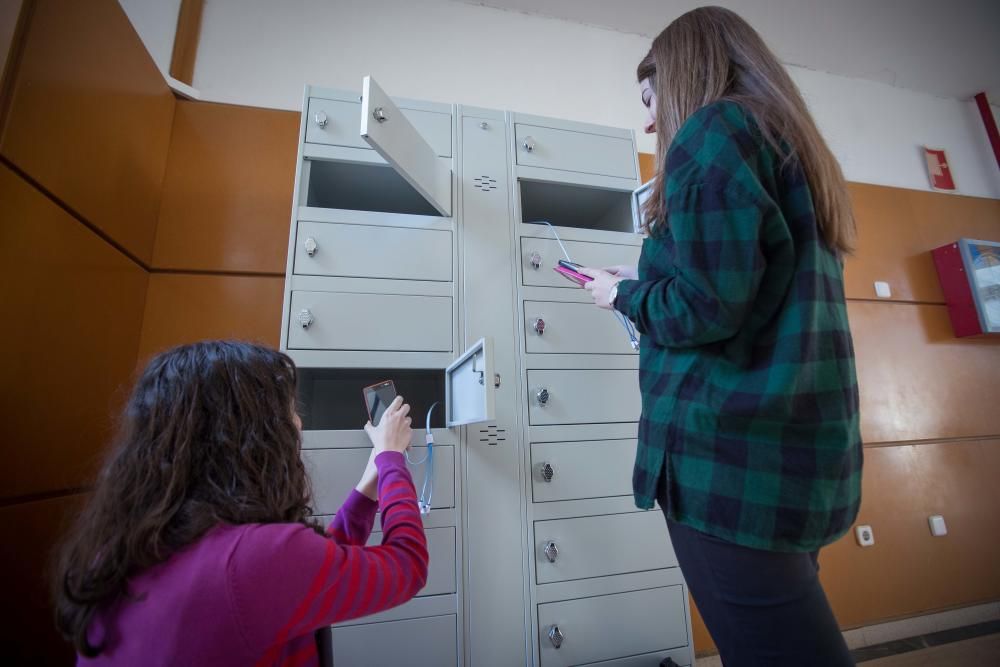 Alumnos usando las taquillas para cargar dispositivos