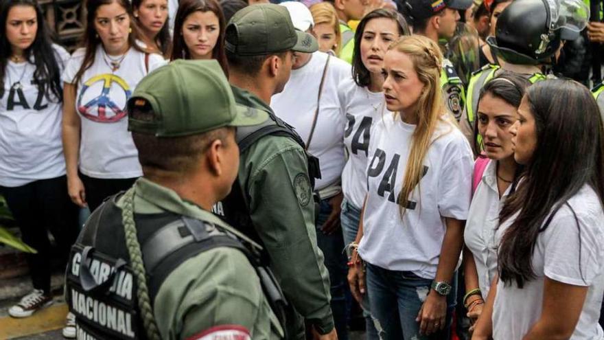 Lilian Tintori, esposa del encarcelado opositor Leopoldo López, dialoga con miembros de la Guardia Nacional Bolivariana en su intento fallido de entrar en la sede del Consejo Nacional Electoral, en Caracas. // Efe