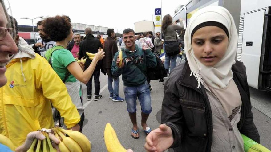 Un grupo de cooperantes austríacos ofrecen fruta a los refugiados . // Faro