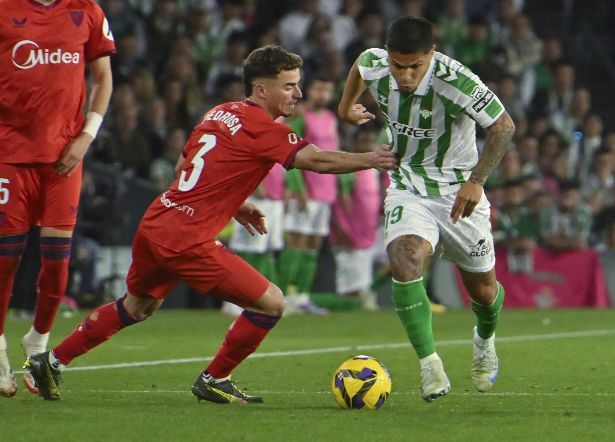 SEVILLA, 30/03/2025.- El delantero colombiano del Betis Cucho Hernández (d) se escapa de Adriá Pedrosa, del Sevilla, durante el partido de la jornada 29 de LaLiga entre el Real Betis y el Sevilla FC, este domingo en el estadio Benito Villamarín.- EFE/Raúl Caro.