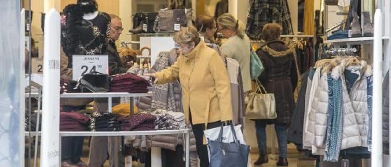 Una señora compra en un establecimiento en el centro de la ciudad de Alicante.