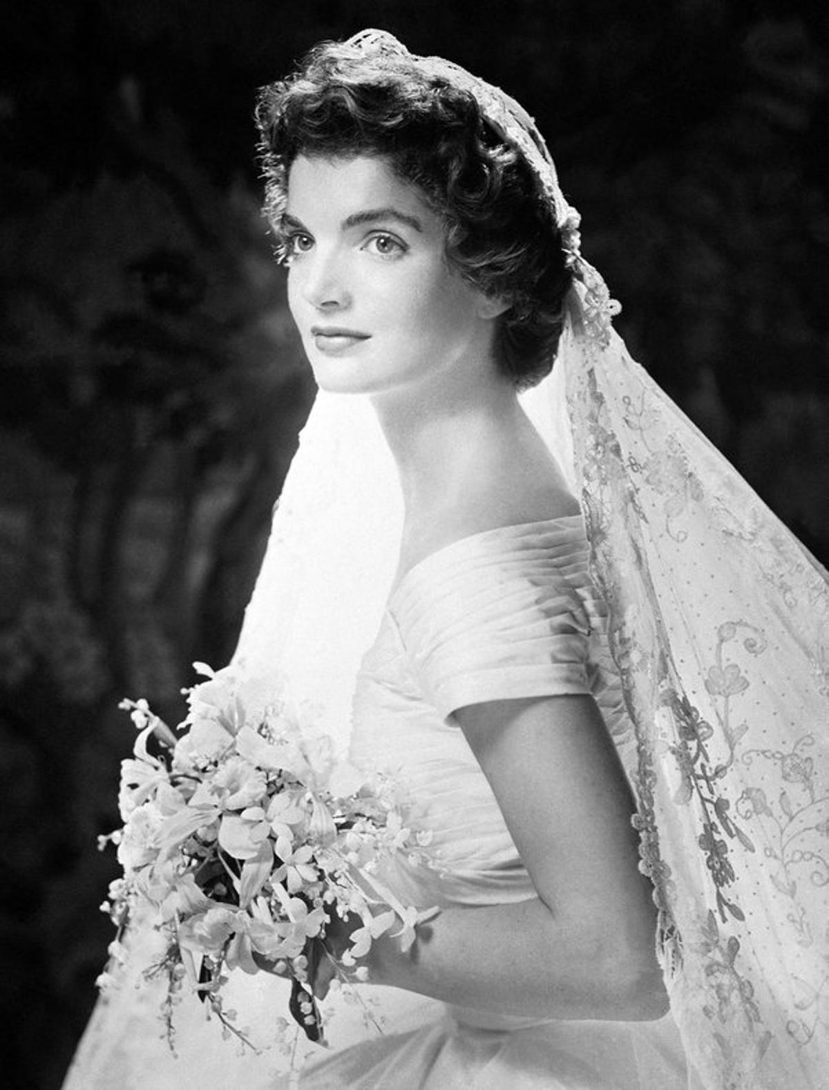 El vestido de novia de Jackqueline Kennedy, un modelo color marfil en tafetán de seda con escote barco, sigue siendo hoy en día uno de los ’looks’ nupciales más imitados.   