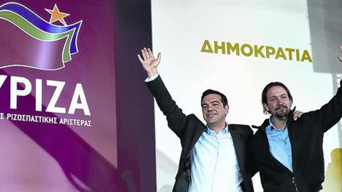 Tsipras, líder de Syriza, se abraza a Pablo Iglesias, su homólogo en Podemos, tras el mitin de ayer en la plaza Omonia de Atenas.