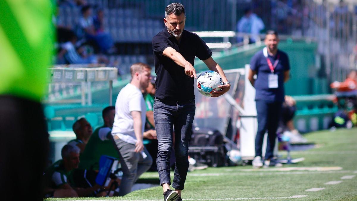 Iván Ania apunta hacia delante mientras sujeta un balón durante el último partido del Córdoba CF.