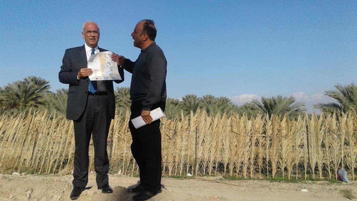 El secretario general de la OLP, Saeb Erekat, sujeta un mapa junto a un experto en asentamientos ante tierra confiscada en Jericó.