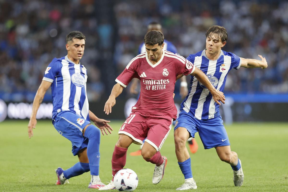 A CORUÑA, 12/08/2026.- El centrocampista del Real Madrid Brahim Díaz (c) se escapa de los jugadores del Deportivo, durante el partido del trofeo Teresa Herrera que Deportivo de A Coruña y Real Madrid disputan este miércoles en el estadio de Riazor, en A Coruña. EFE/Cabalar