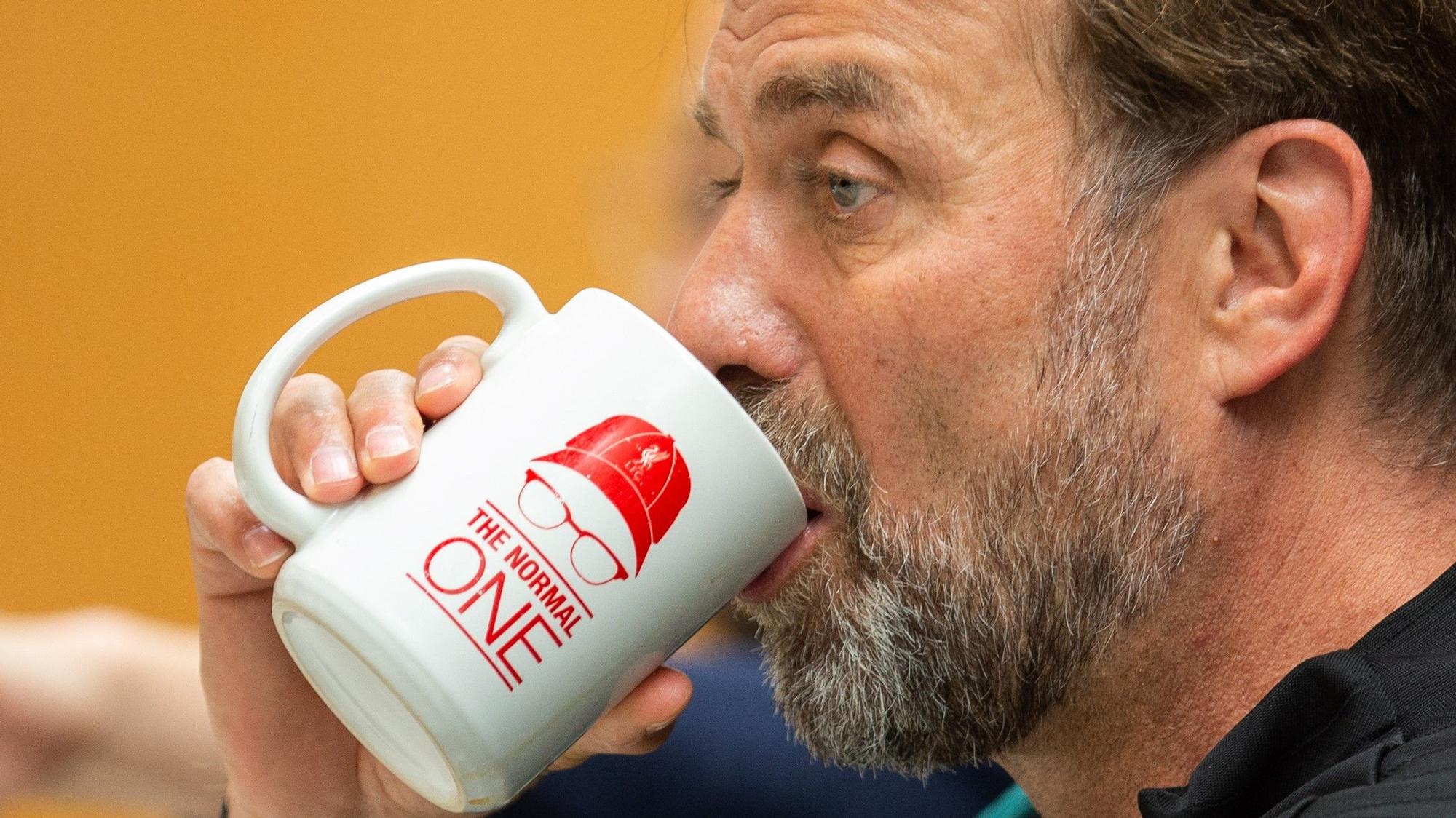Jürgen Klopp bebe de una taza con la inscripción: "El normal"