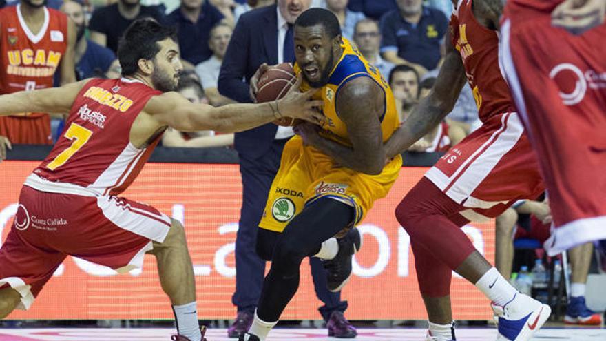 El base de Herbalife Gran Canaria Bo McCalebb protege el balón ante el base Facundo Campazzo y el alero Ovie Soko, de UCAM Murcia.