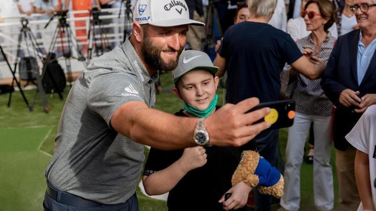 El golfista Jon Rahm con uno de los niños del hospital.