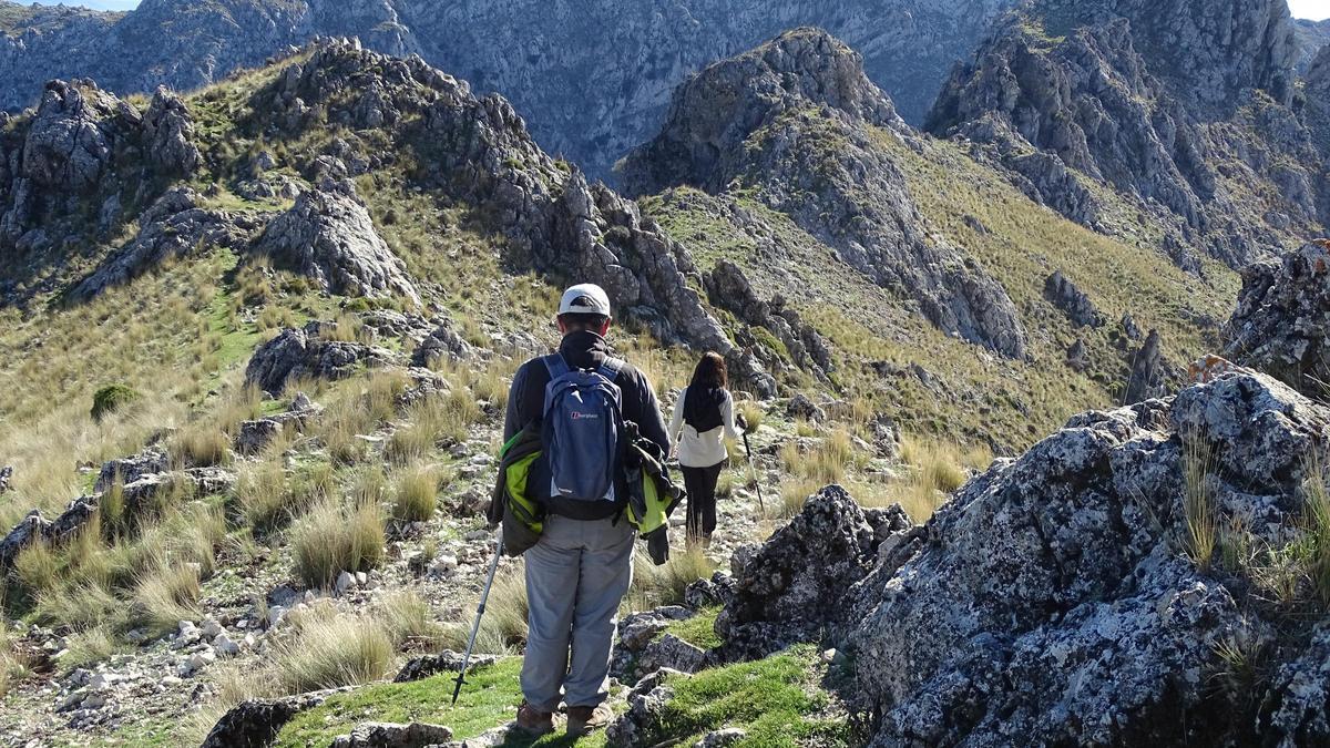 Dos senderistas descienden la cumbre por las crestas de Bermejo, en Priego.