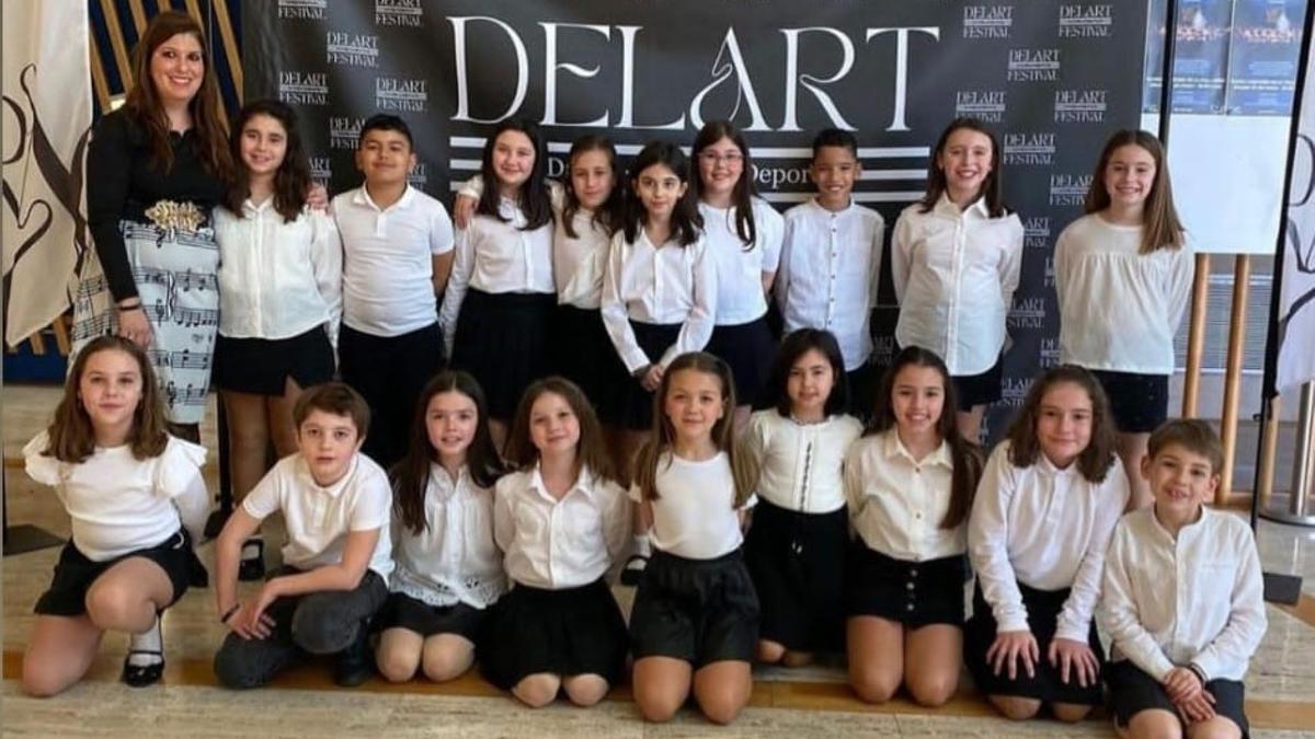 Los Peques Cantores de Lugones, durante su participación en DelArt Festival, con su profesora y directora coral, Jessica Suárez.