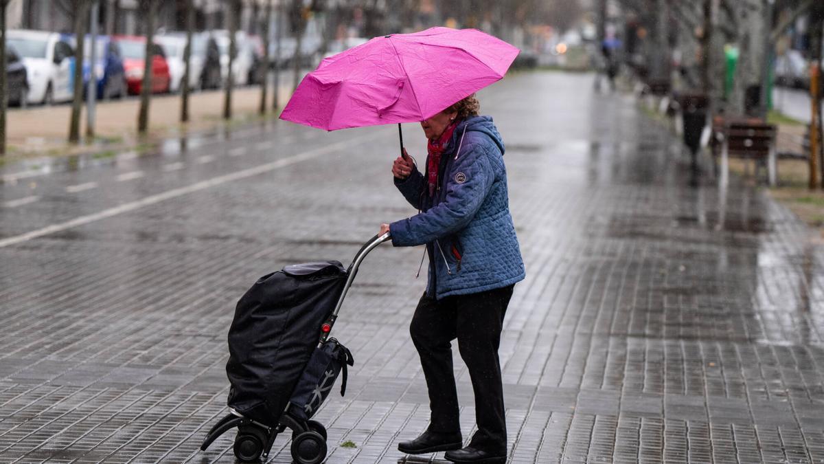 Persona protegiéndose con un paraguas en las calles durante la lluvia.